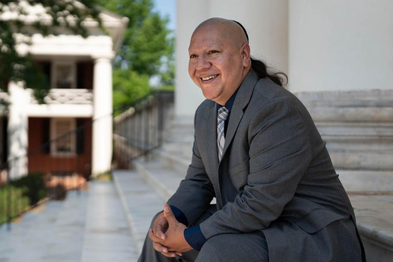 Kody Grant, UVA Tribal Liaison sitting on the stairs of the Rotunda.